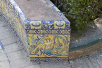 A colourful, Moorish style, tiled bench at the Real Alcazar Palace gardens, Seville. Spain. September. 