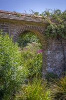 Looking towards the arch from the Mosaic Garden into the Barn Garden at Great Dixter