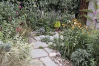 Stone patio area in contemporary garden with Helenium 'Waltraut'
and Espalier apple tree 'Cox's Orange Pippin'
