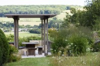 Wooden pergola in a country garden in July