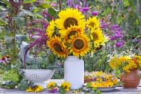 Sunflower bouquet in a milk churn and harvested pot marigolds and calabrese.