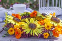 Summer wreath made of annuals including sunflowers, nasturtium, marigold and amaranthus.