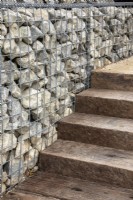 Gabions filled with stone offcuts form a wall next to steps made from reclaimed wood - designers Caroline and Peter Clayton - Get Started Gardens -  Nurturing Nature in the City -  RHS Hampton Court Palace Garden Festival.