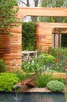 Ornamental wooden arches made of Red Cedar in the garden, Prunus maackii Amber Beauty, Euphorbia, Iris germanica Bronze, Libertia grandiflora, Pittosporum tobira Nanum 