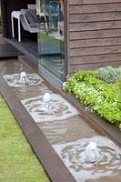 Terrace with water feature, water channel, Galium odoratum, Stipa tenuissima, Buxus 