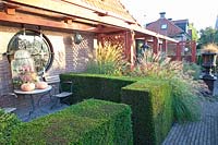Front garden with yew hedges and fountain grass, Pennisetum alopecuroides 