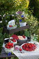 Etagere with dishes, strawberry cake and strawberries 