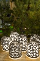 Group of luminescent, handmade brass lamps on terrace by the Pinus sylvestris - Pine. 
Designer: Vetschpartner, Berger Gartenbau and Livingdreams. Giardina-Zurich, Swiss.
. 

