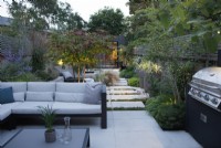 View of the seating area and outdoor kitchen in this city garden which can be used day or night thanks to the outdoor lighting