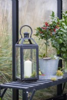 Lantern on shelving inside greenhouse