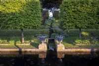 Two large formal urns at the end of the rill that cascades into the formal pond