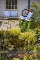 Urban front garden with a storage pond and seating area. Recycled seats from an old model Citroen car placed on a mosaic surface made from various reclaimed natural materials. Designer: Nicola Haines, Citroen Power of One at Bord Bia Bloom Dublin 2023