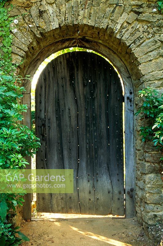 Wall with arched door leading to the summer garden at Munstead Wood in Surrey