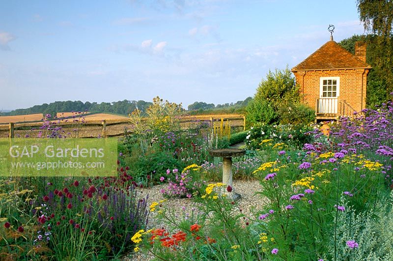 Dry gravel garden birdbath and herbs and view to countryside and house at Frith Hill in Sussex