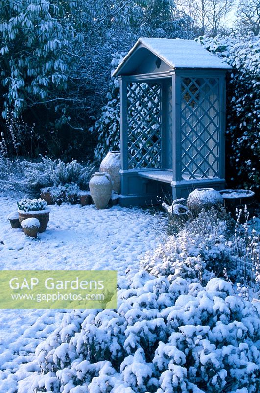 Wooden gazebo in winter garden with snow. Fairfield in Surrey
