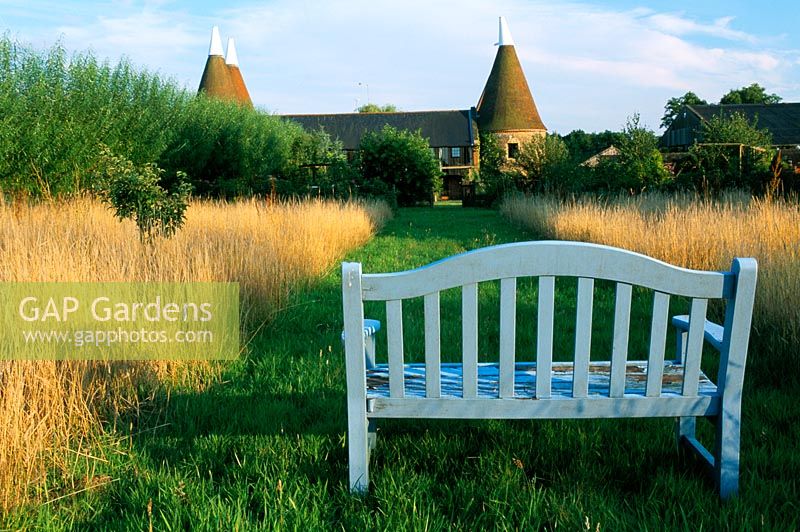Blue bench at the end mown grass path
Oast Houses in Hampshire