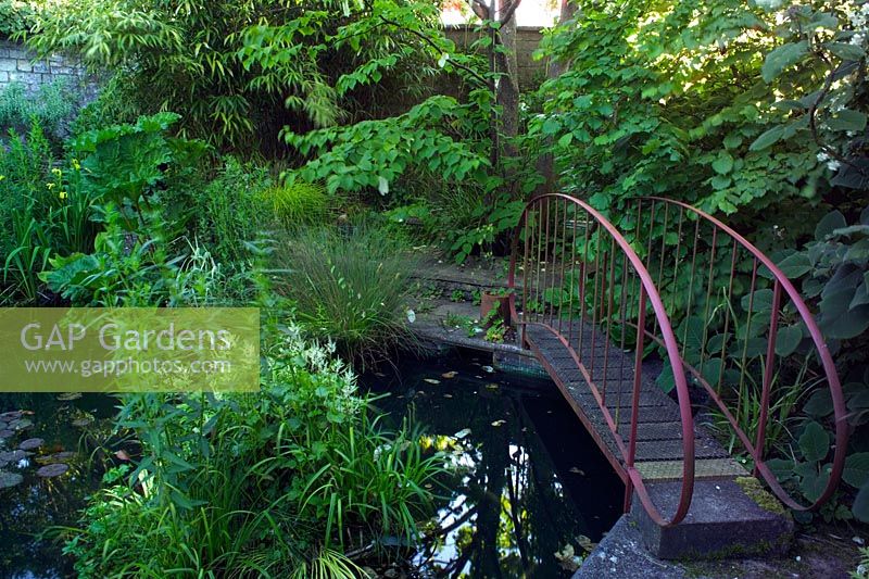 Bridge over pond converted from swimming pool at Brewery House in Somerset