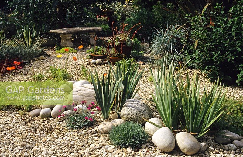 Dry gravel garden with stones and bench at Heathfield in Surrey