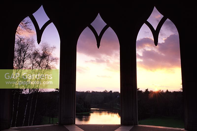 View through arched windows from Gothic Tower to lake at Painshill Surrey