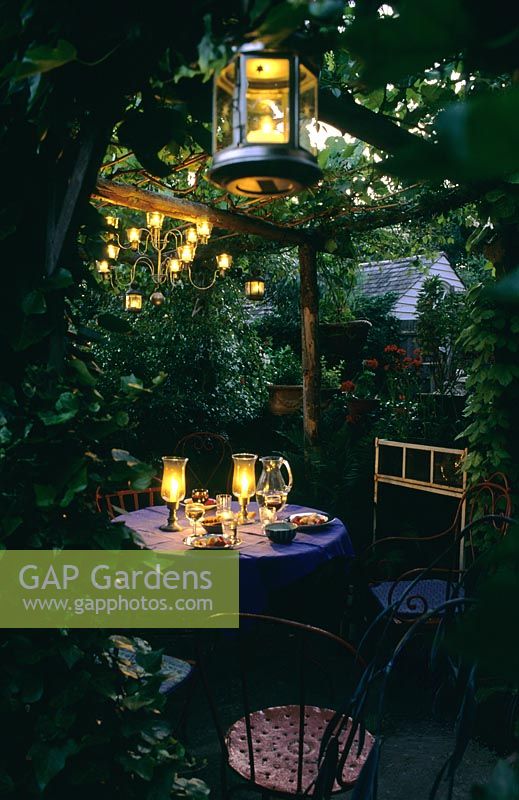 Lighting at outdoor eating area under pergola in garden at Park Terrace in Sussex