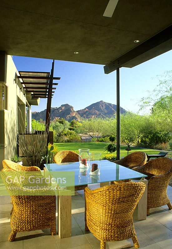 Wicker furniture and dining table on patio in The Kotoske Garden in Phoenix Arizona USA