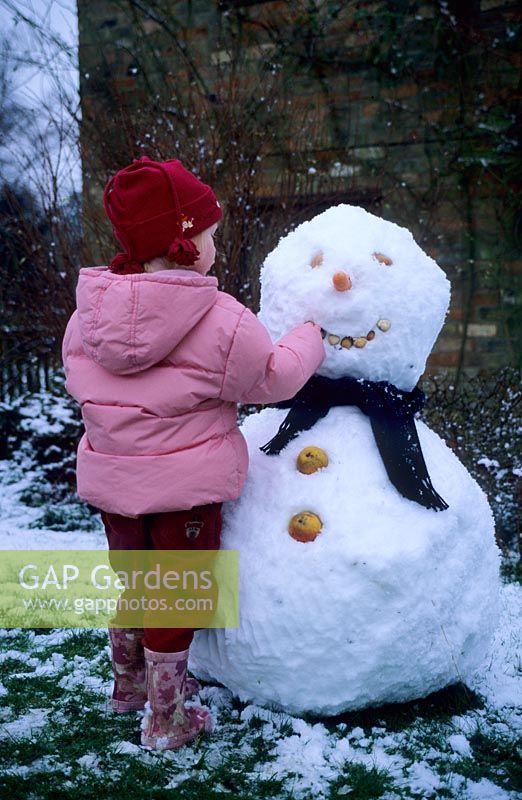 Child making snowman at Gowan Cottage in Suffolk 