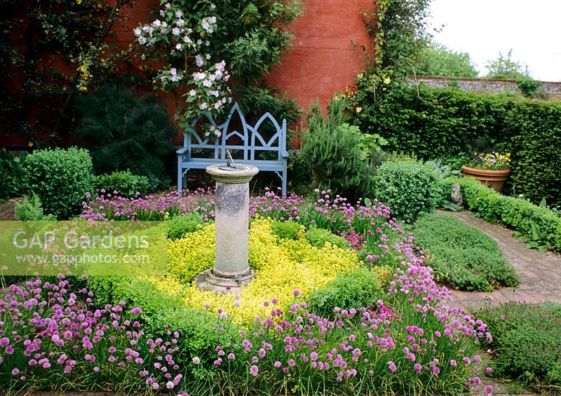 Herb garden at Wyken Hall with Gothic style wooden bench and sundial