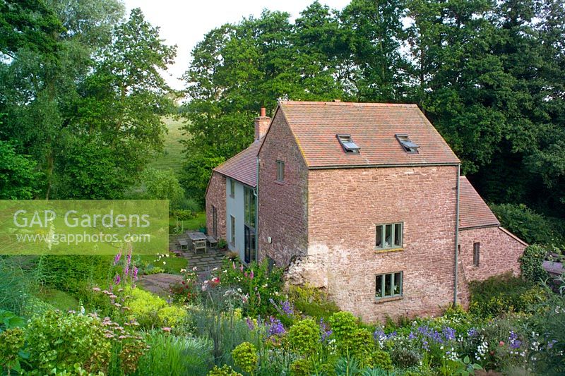 View of house set in informal country garden at The Old Cornmill, Herefordshire 
