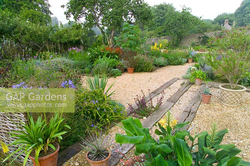Dry gravel garden with railway sleeper steps at Meadow Nursery, Wells in Somerset  