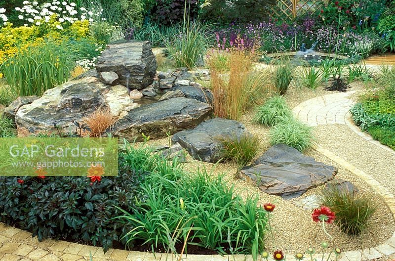 Dry gravel garden with rocks, waterfall and winding path.  