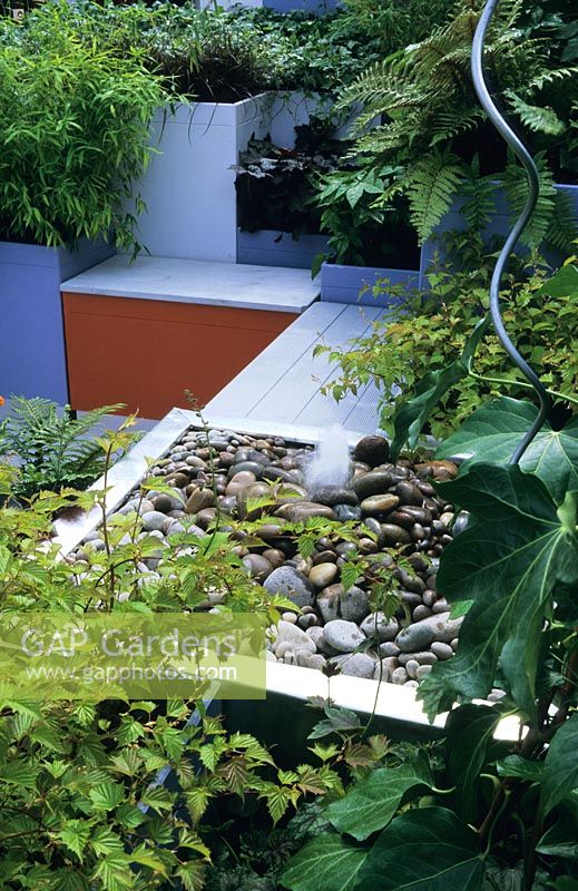 Contemporary roof garden with perennials, raised beds, decking and water feature
