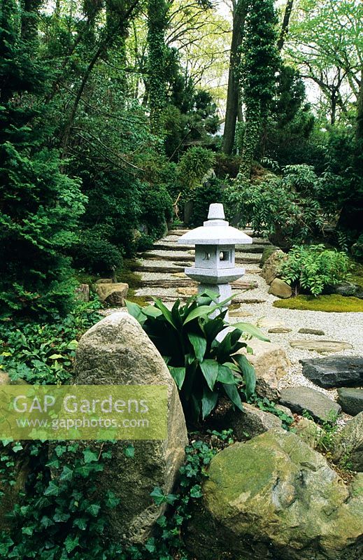 Japanese Stroll Garden. Path and steps through garden with wind temple statue 