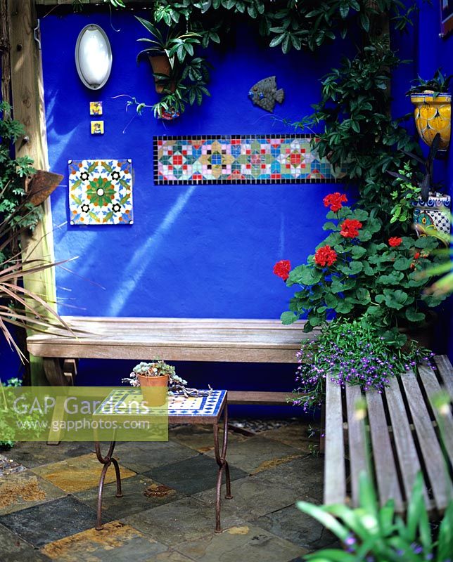 Small patio area with timber bench seats and blue courtyard walls