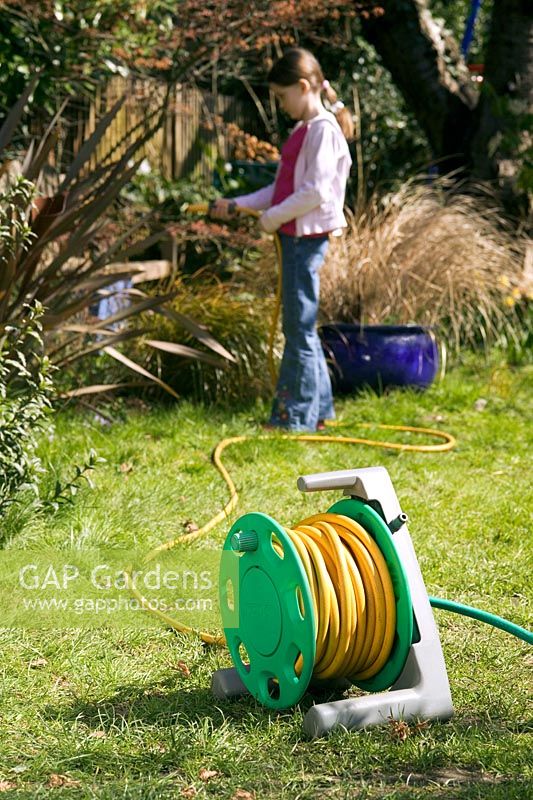 Girl unwinding hose from reel