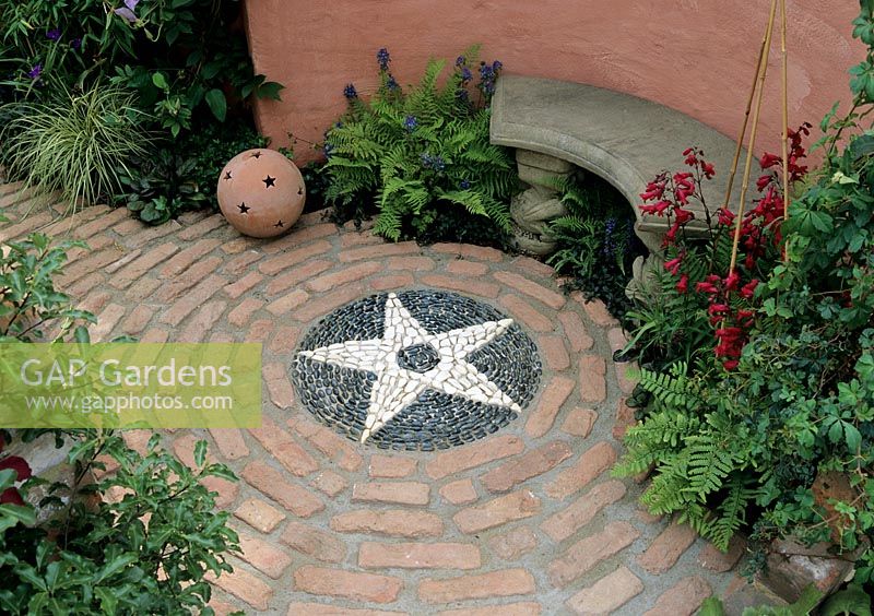 Courtyard garden - Brick circle with black and white cobble stone circle. 