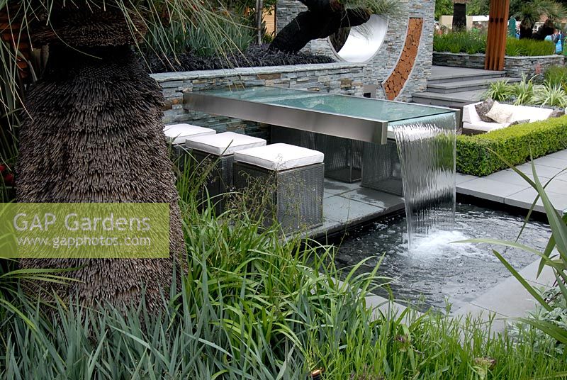 Outdoor seating area with a table water fountain and pool