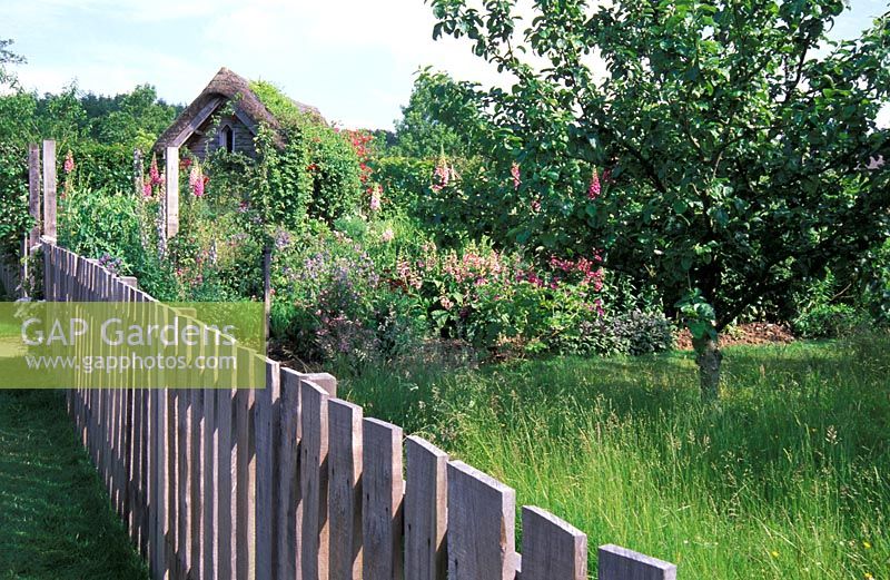 Chestnut picket fence with view to the Potager and Herb Garden at RHS Garden Rosemoor, Devon