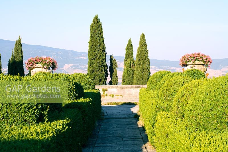 Large Tuscan garden with clipped boxed topiary hedging and view accross the countryside, Villa La Foce, Italy