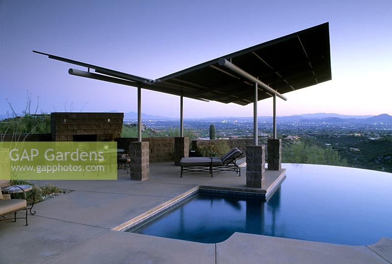 Contemporary metal gull winged sunshade over Infinity pool looking over Tucson