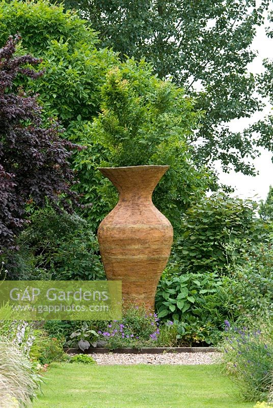 The long borders with ornmental grasses. Sculpture by Mayanne Nicholls called The Vessel. 27 June. Lucy Redman's School of Garden Design, Rushbrook, Nr. Bury St. Edmunds, Suffolk. 