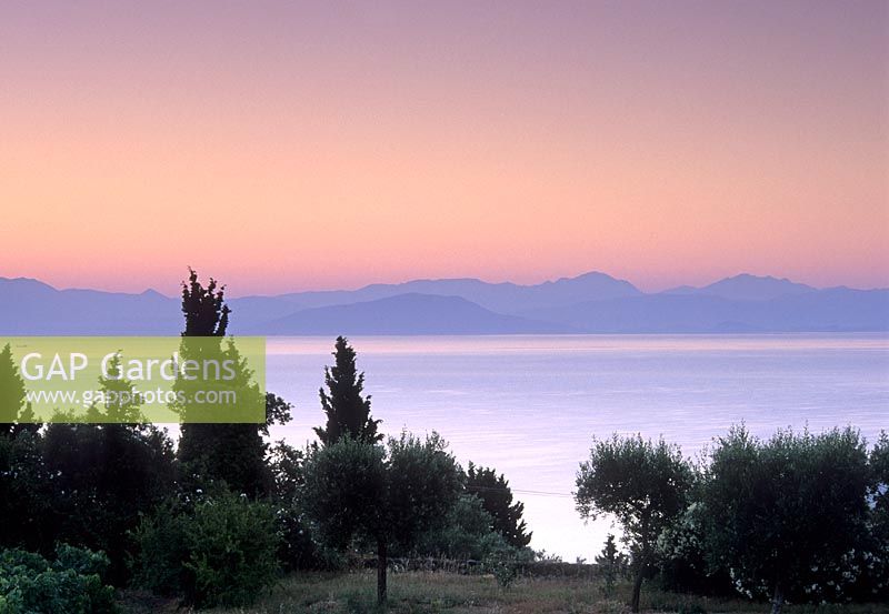 View from garden across sea to mountains beyond with beautiful late evening sky - Corfu

