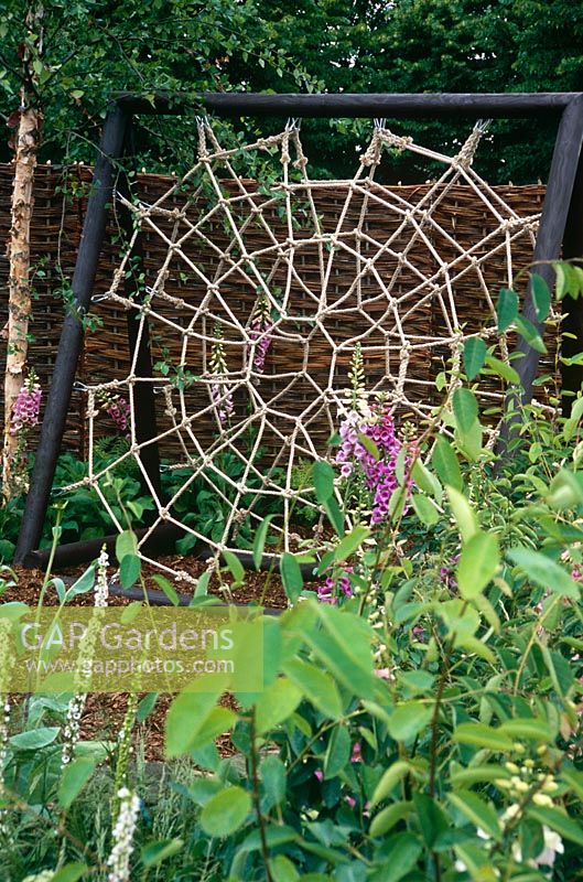 Climbing frame shaped like a spider's web made out of rope with wooden frame - The Volvo Garden, Hampton Court Flower Show 2005 