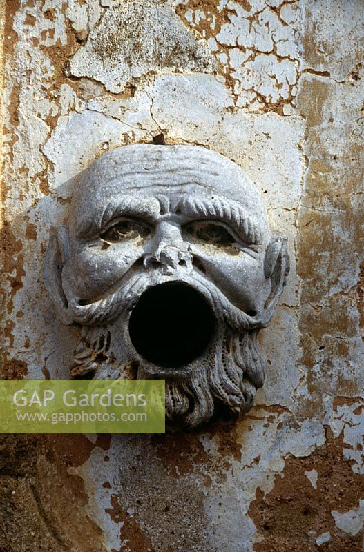 Open-mouthed stone face of man on wall used for extinguishing flaming torches - Villa Palagonia, Palermo, Sicily 
