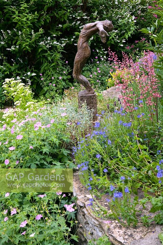 Bronze statue of woman in informally planted summer bed - Hillesley House, Gloucestershire