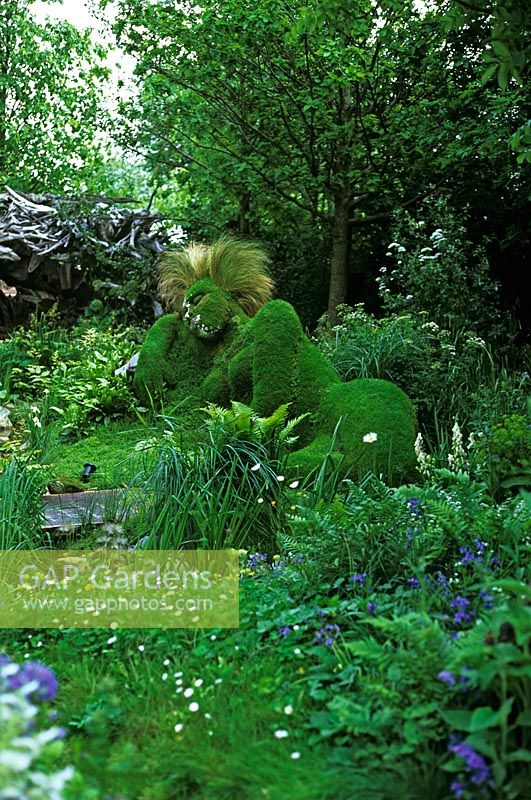 The 4head Garden at Chelsea Flower Show 2006 - Heather and turf reclining woman with mirror chips on face and Stipa as hair - Sculptors - Sue Hill and Peter Hill
