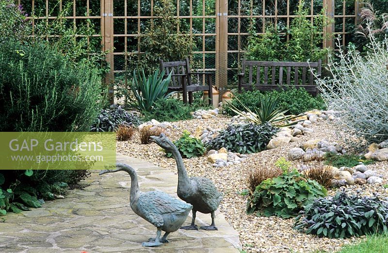 Geese sculptures in gravel garden with drought tolerant planting