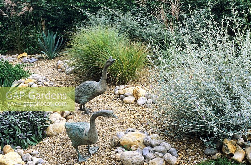 Geese sculptures in gravel garden with drought tolerant plants