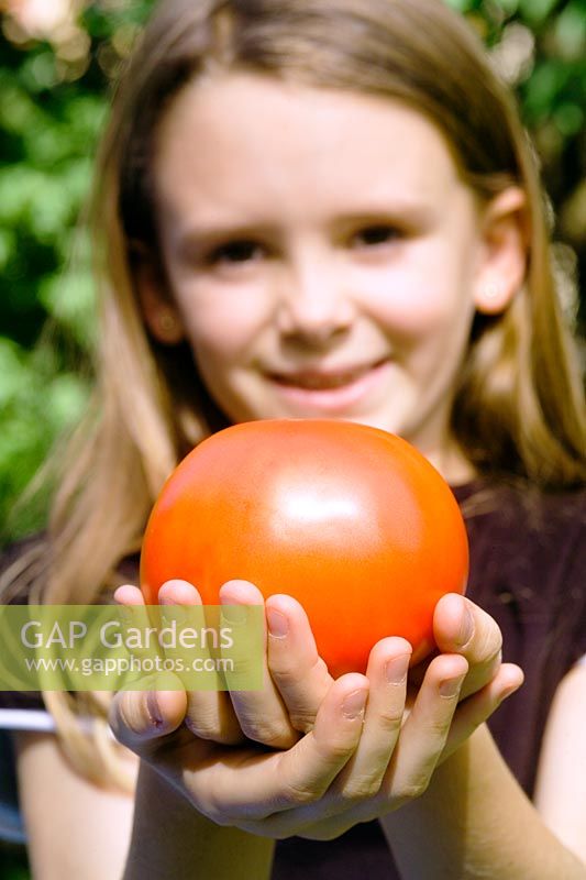Girl holding tomato