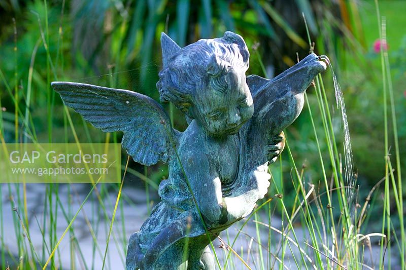 'Winged fairy' statue in pond area at Heligan Garden, Cornwall  