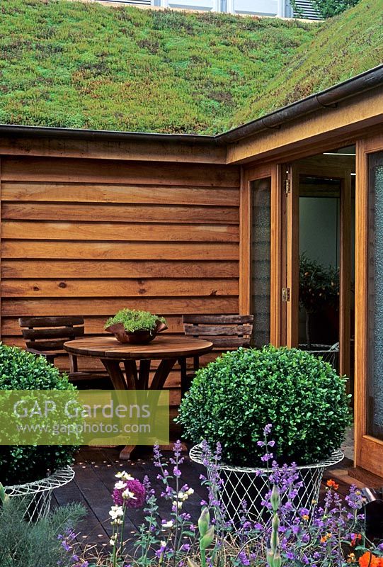 Wood framed house with living roof - Table, chairs and buxus spheres in pots - RHS Chelsea 2003
